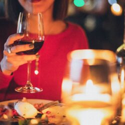 woman holding wine glass selective focus photography