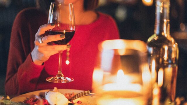 woman holding wine glass selective focus photography