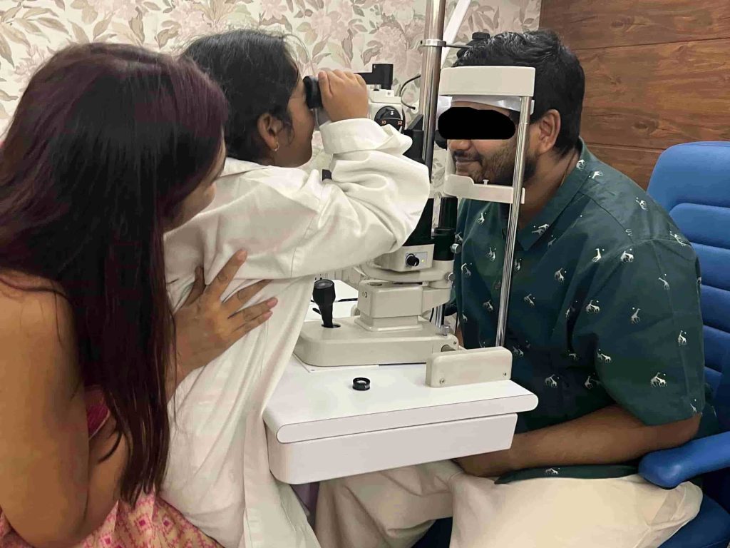 Dr Shibal Bhartiya performing a comprehensive paediatric eye examination in Gurgaon. The young patient plays doctor, wearing Dr Bhartiya's coat,, hops into her lap and examines a "patient"